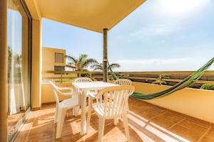 a balcony with a table and chairs and a view of the ocean at Townhouse La Tejita in La Tejita