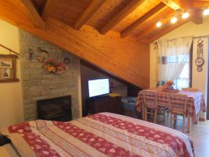 a room with two beds and a fireplace and a television at Borgo Alpino Chalet 4 in Aprica