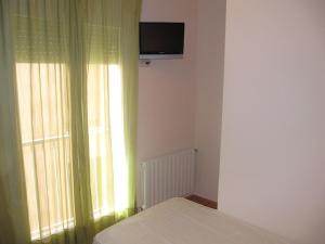 A television and/or entertainment centre at Hostal La Vila