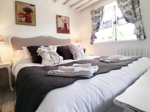 a bedroom with a large white bed with towels on it at La Romance et la Romanesque in Berville-sur-Mer