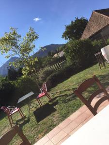 un grupo de sillas sentadas en el césped en un patio en Auberge du Grand Champ, en Lalley