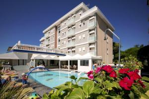 un hotel con piscina frente a un edificio en Hotel Danieli, en Caorle