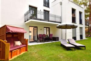 a backyard with a patio furniture and an umbrella at Villa Sofie Binz in Binz