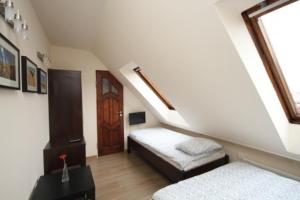 a attic room with a bed and a window at Ekonomiczne Pokoje Gościnne Dask Holiday in Łeba