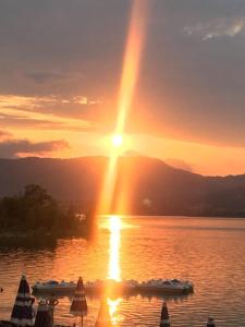 Il lago del Mugello B&B في باربيرينو دي موجيلو: غروب الشمس على البحيرة مع وجود قوارب في الماء