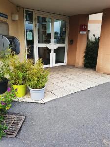 un edificio con dos macetas delante de la puerta en Good Night Hotel, en Arques