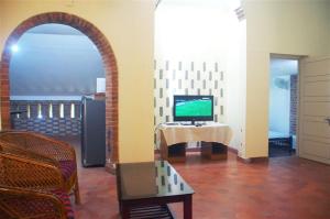 - un salon avec une arche et une télévision sur une table dans l'établissement Tagore Homestay Villa Trivandrum, à Trivandrum