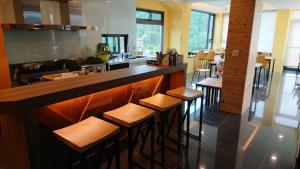 a kitchen with a bar with wooden stools at Zhaohong homestay in Yuchi