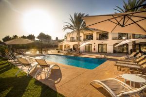 a swimming pool with lounge chairs and a resort at Aparthotel Camp El Planet in Alfaz del Pi