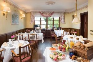 ein Restaurant mit Tischen und Stühlen mit Essen darauf in der Unterkunft Hotel Linther Hof in Linthe