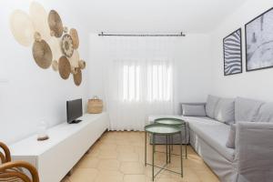 Apartments Mar de Tossa في توسا ذي مار: غرفة معيشة بيضاء مع أريكة وطاولة