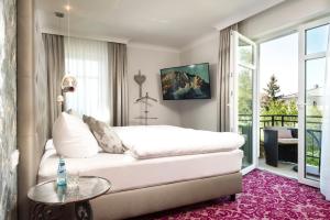 Schlafzimmer mit einem weißen Bett und einem Glastisch in der Unterkunft Hotel Linther Hof in Linthe