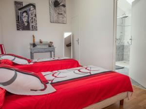 two beds in a room with red sheets at La Maynadie in Andouque +31 photos