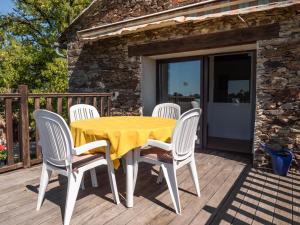 a yellow table and chairs on a wooden deck at La Maynadie in Andouque
