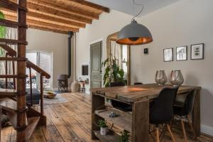 a dining room with a wooden table and chairs at De zeeuwse Suites in Middelburg