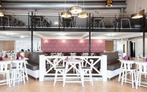 a restaurant with white tables and white stools at Donna Hotel Klosterhof in Neukirchen beim Heiligen Blut