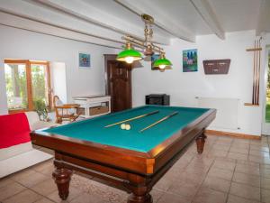 a room with a pool table with cuesticks on it at La Maynadie in Andouque