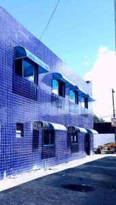 馬塞約的住宿－POUSADA OLÍMPIA，蓝色砖砌建筑的侧面设有阳台