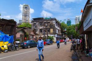 a man walking down a street in a city at Hotel Tourister in Mumbai