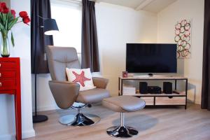 a living room with a chair and a television at Ostrea 16 in Kamperland