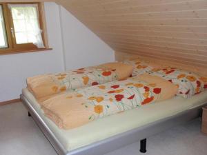 ein Bett mit zwei Kissen auf einem Zimmer in der Unterkunft Ferienwohnung Brülisauer in Brülisau