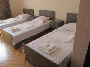 drie bedden in een kamer met witte handdoeken erop bij Hotel Classic in Telavi