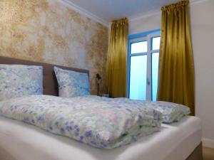 Un dormitorio con una cama grande con ventana. en Gartensuite No.5@Haus Mateika, en Westerland