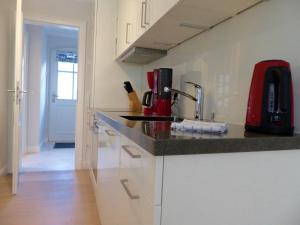 a kitchen with a counter and a red appliance at Gartensuite No.5@Haus Mateika in Westerland