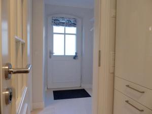 a hallway with a white door with a window at Gartensuite No.5@Haus Mateika in Westerland (Sylt)