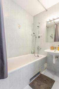 a white bathroom with a tub and a sink at #inVilnius - Spacious & Bright 1BDR Apartment Shopping District in Vilnius +33 photos