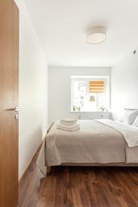 a white bedroom with a bed and a window at #inVilnius - Spacious & Bright 1BDR Apartment Shopping District in Vilnius