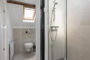 a bathroom with a shower and a toilet at De zeeuwse Suites in Middelburg +34 photos