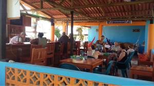 un grupo de personas sentadas en mesas en un restaurante en Johnny Fiestas, en Las Lajas