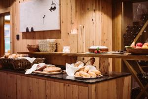 un bancone di panetteria con piatti di prodotti da forno e pane di Hotel Chalets Grosslehen a Fieberbrunn