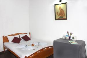 a bedroom with a bed with a table and a picture on the wall at Old Dutch House in Galle