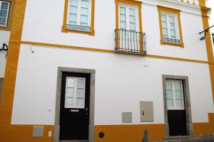 un edificio blanco con puertas y ventanas negras en Flamingo House - historic center free garage, en Évora