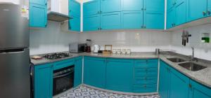 una cocina azul con armarios azules y fregadero en Hostal Casa Aborigen, en Santiago