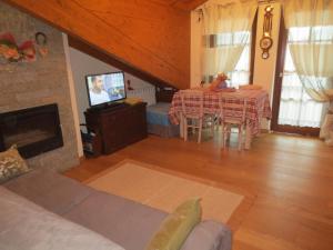 sala de estar con chimenea y mesa con TV en Borgo Alpino Chalet 4, en Aprica