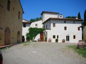 une grande maison blanche avec une allée. dans l'établissement Le Rose al Nibbio in Toscana, à Reggello