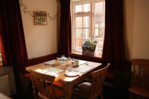 a wooden table with chairs and a window at The Horseshoe Guesthouse in Rhayader