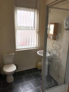 a bathroom with a toilet and a sink and a window at Beach View Holiday Flats in Blackpool