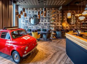 um velho carro vermelho estacionado numa sala com um bar em ibis Le Mans Centre Gare Nord em Le Mans