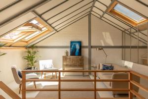 - un bureau mansardé avec un bureau et des lucarnes dans l'établissement Romantic - Garden of Camellias, à Porto