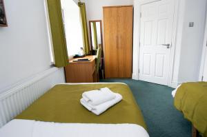 Habitación con 2 camas y toalla blanca en la cama en Plas y Brenin en Capel-Curig