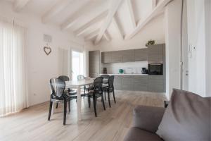 eine Küche und ein Esszimmer mit einem Tisch und Stühlen in der Unterkunft Terrazze sul Garda in Tenno