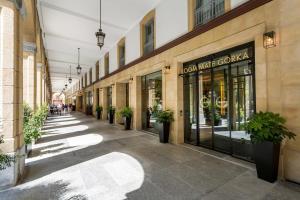 an empty shopping mall with potted plants on the sidewalk at Room Mate Collection Gorka, San Sebastián in San Sebastián