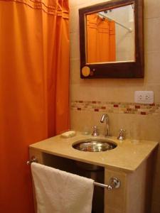 y baño con lavabo y cortina de ducha de color naranja. en Rinconcito en Tilcara en Tilcara