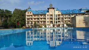a hotel with a swimming pool in front of a building at Blue Mare Rac in Łukęcin