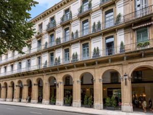 a large white building with arches and windows at Room Mate Gorka in San Sebastián