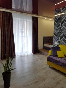 een woonkamer met een bank en een groot raam bij Квартира Lux 2018 года in Charkov